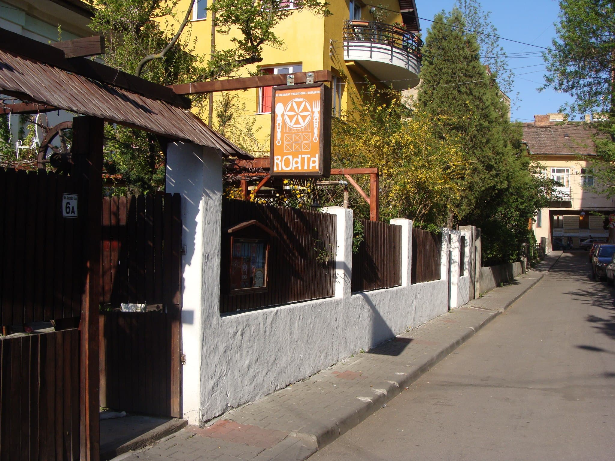 Intrarea în Restaurant Roata, cu poartă de lemn și decor tradițional
