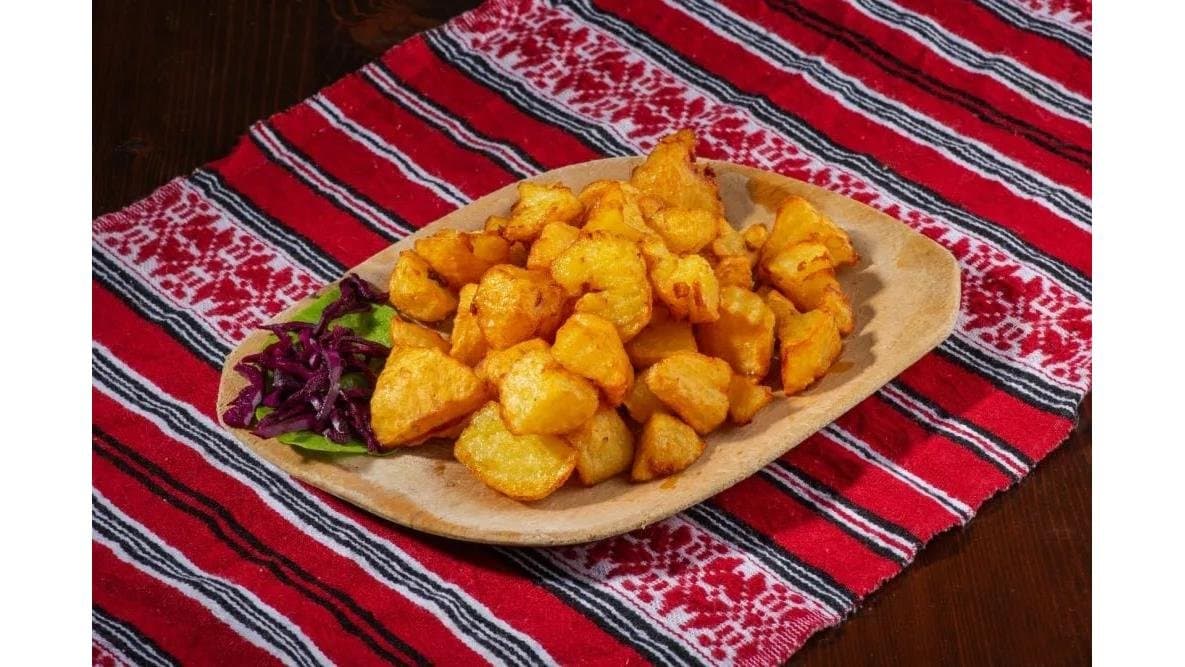 Cartofi prăjiți cu garnitură de salată, pe ștergar tradițional